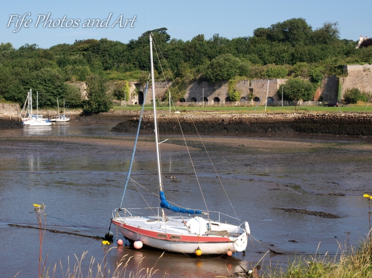 Small yacht at Charlestown Harbour, Fife, with lime kilns in the background